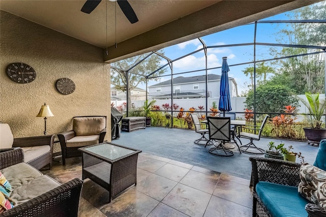 view of patio featuring ceiling fan, an outdoor hangout area, and glass enclosure