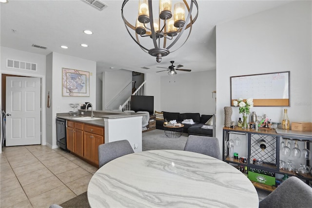 tiled dining room with sink and ceiling fan with notable chandelier