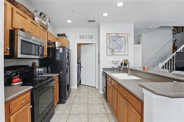 kitchen with sink, light tile patterned floors, and black appliances