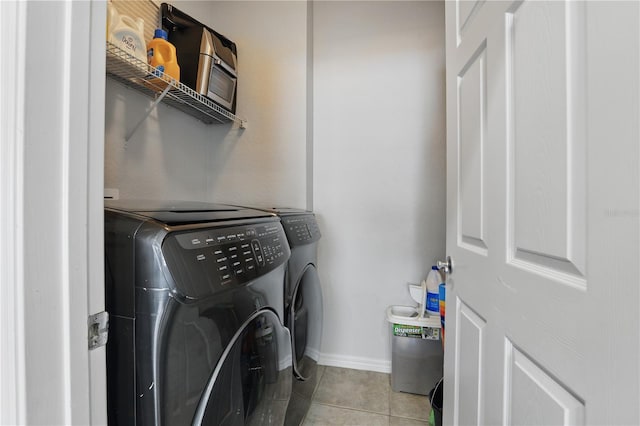 laundry room featuring washing machine and clothes dryer and light tile patterned flooring