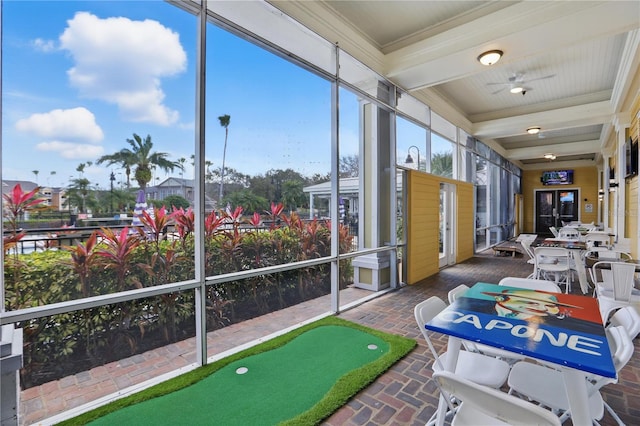 sunroom / solarium featuring beam ceiling