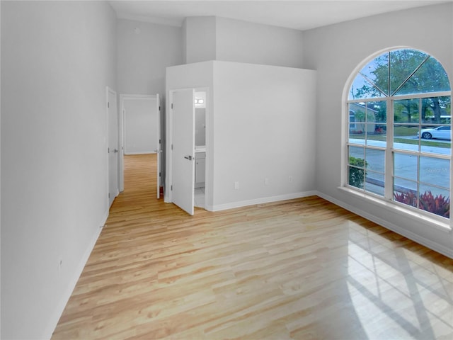 empty room with light hardwood / wood-style flooring and plenty of natural light