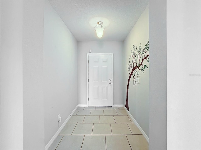 doorway featuring a textured ceiling and light tile patterned floors