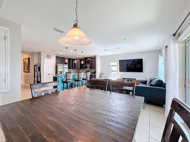 tiled dining area with a textured ceiling