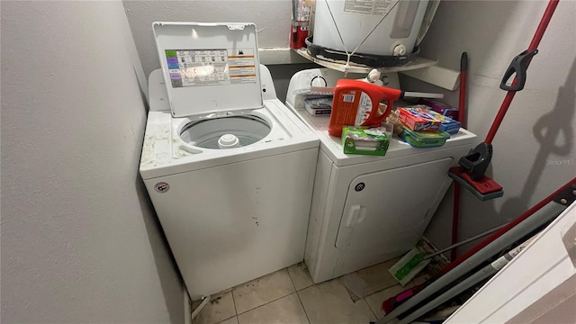 laundry room with washer and clothes dryer and light tile patterned floors