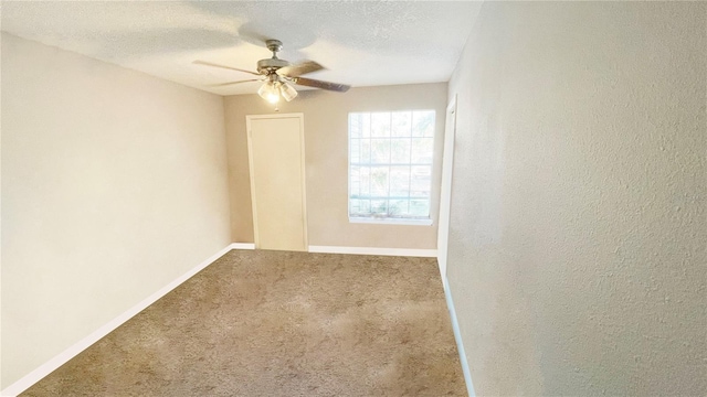 empty room with ceiling fan, carpet, and a textured ceiling