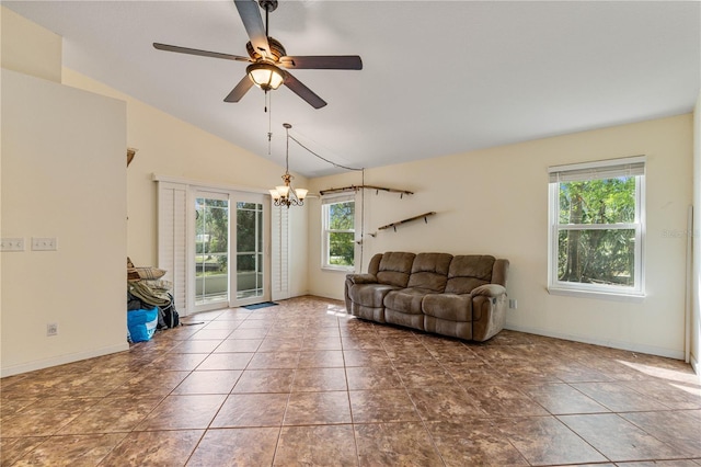 tiled living area with lofted ceiling, ceiling fan with notable chandelier, and baseboards