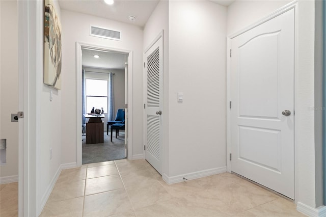 hall featuring light tile patterned flooring