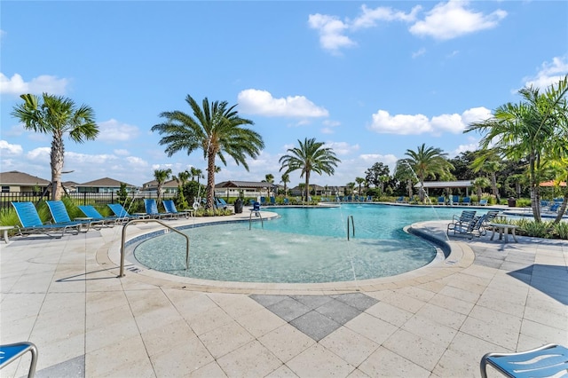 view of swimming pool featuring pool water feature and a patio