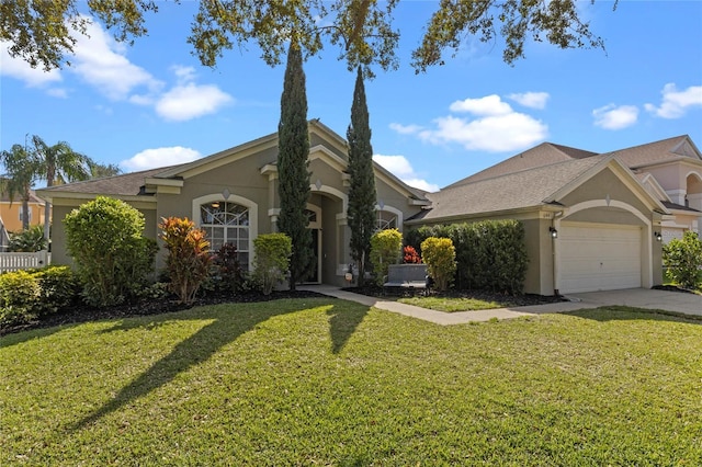 view of front of house with a garage, a front yard, concrete driveway, and stucco siding