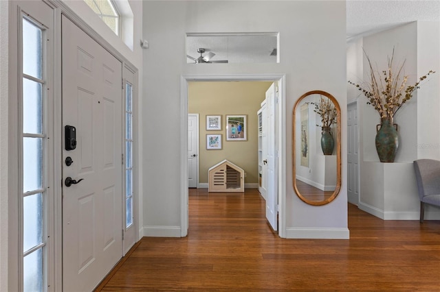 foyer featuring baseboards and wood finished floors