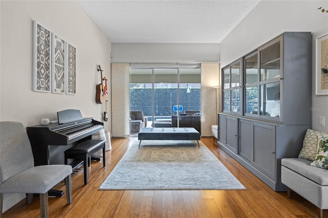 sitting room with a textured ceiling and wood finished floors