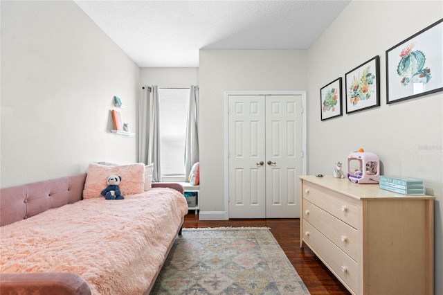 bedroom with a closet, dark wood-style flooring, and a textured ceiling