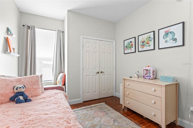 bedroom featuring dark wood-style floors, a closet, and baseboards