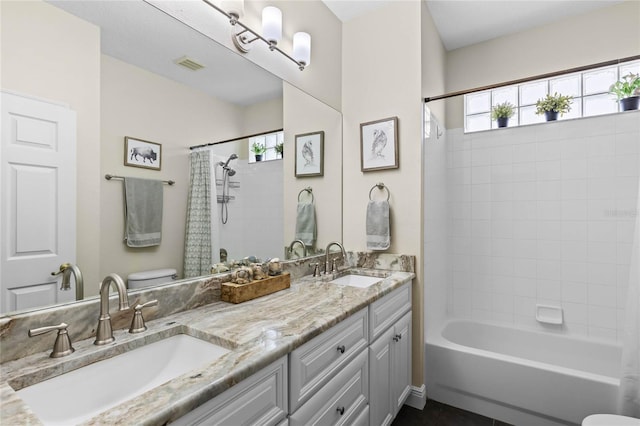 bathroom with toilet, a sink, and visible vents