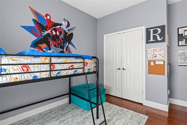 bedroom featuring a closet, baseboards, and wood finished floors