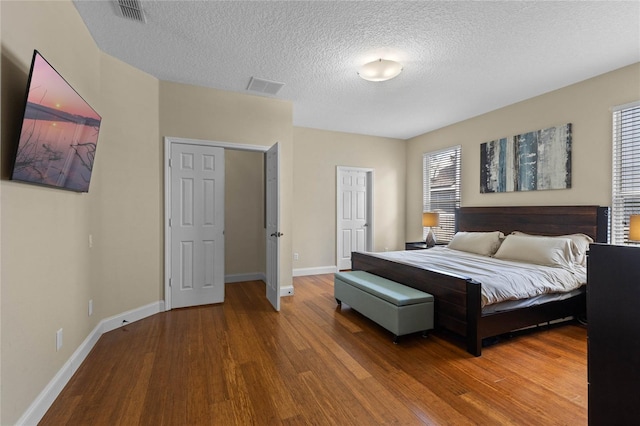 bedroom featuring wood finished floors, visible vents, and baseboards