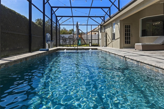 view of pool with glass enclosure, a patio area, and a fenced in pool