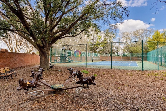 view of sport court featuring playground community and fence