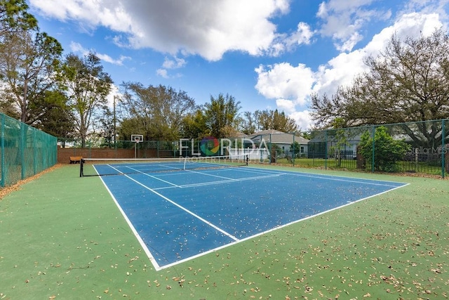 view of tennis court featuring fence