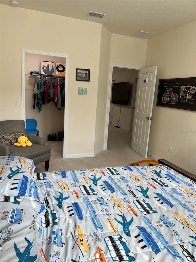 carpeted bedroom featuring a walk in closet and a closet