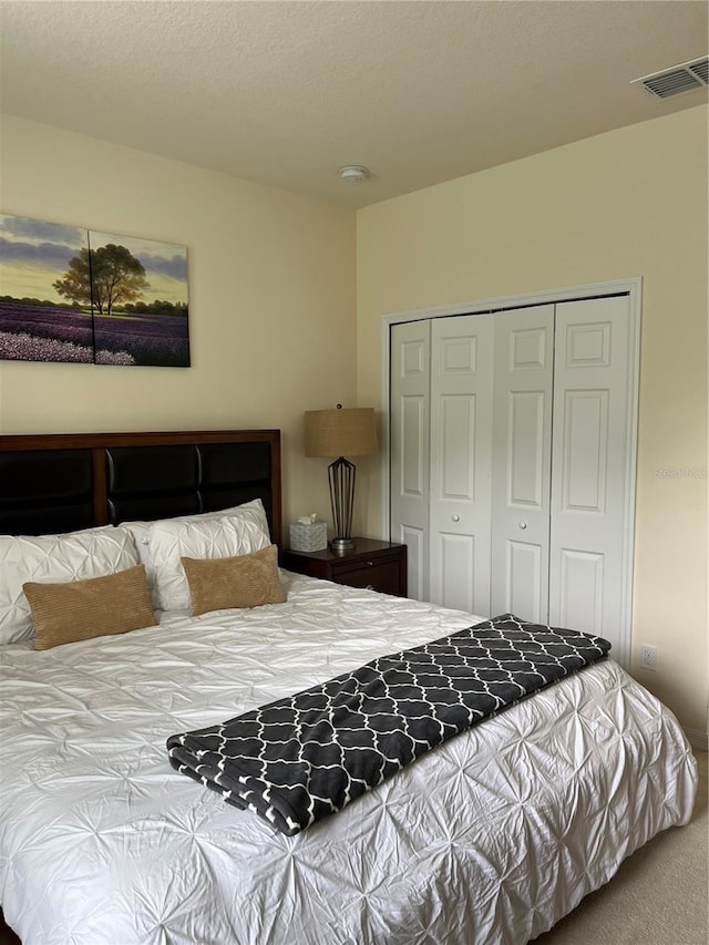 carpeted bedroom featuring a closet and a textured ceiling