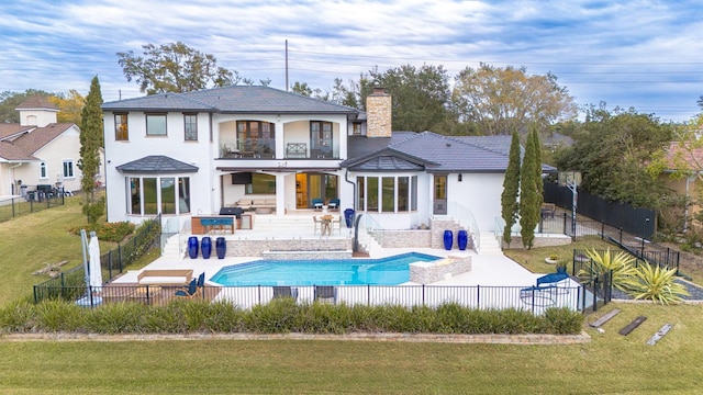 rear view of house featuring a patio area, a fenced backyard, a yard, and a balcony