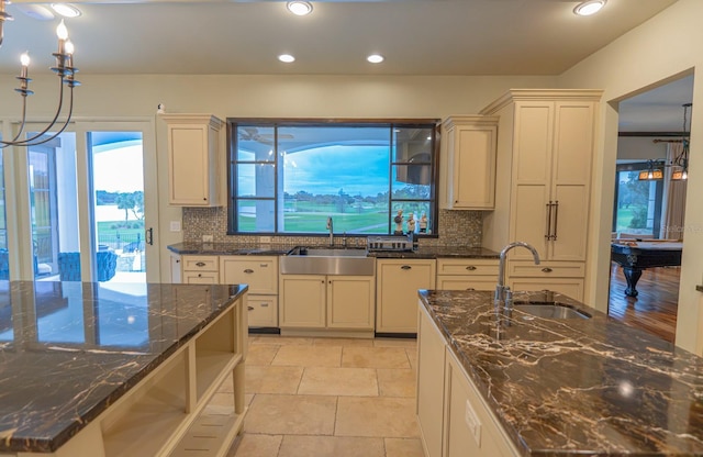 kitchen featuring dark stone countertops, backsplash, and a sink