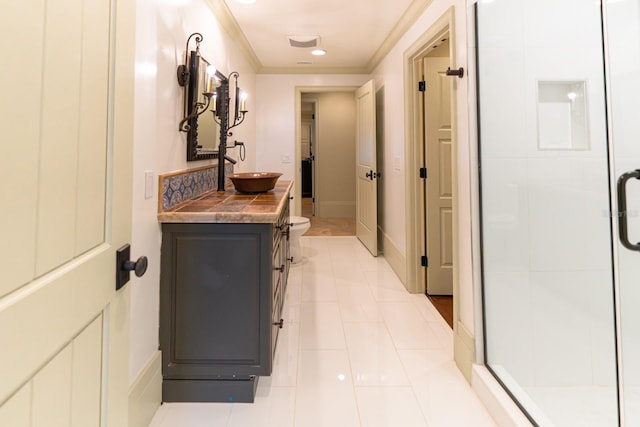 hallway featuring crown molding, light tile patterned flooring, a sink, and baseboards