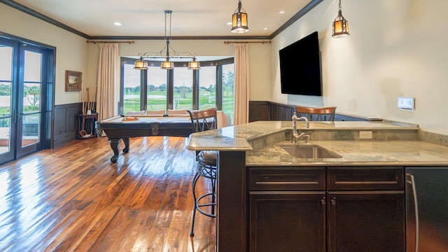 interior space featuring crown molding, dark wood finished floors, wainscoting, and a sink