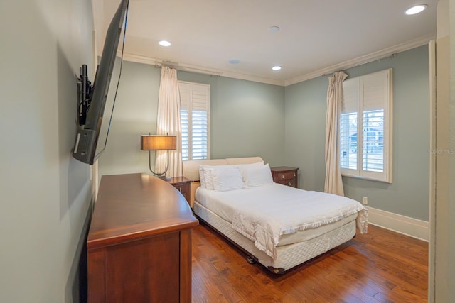 bedroom with multiple windows, ornamental molding, and wood finished floors