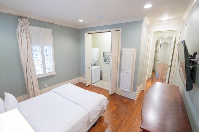 bedroom with baseboards, ornamental molding, stacked washer / drying machine, and wood finished floors