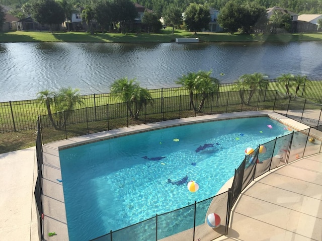 view of pool featuring a lawn and a water view