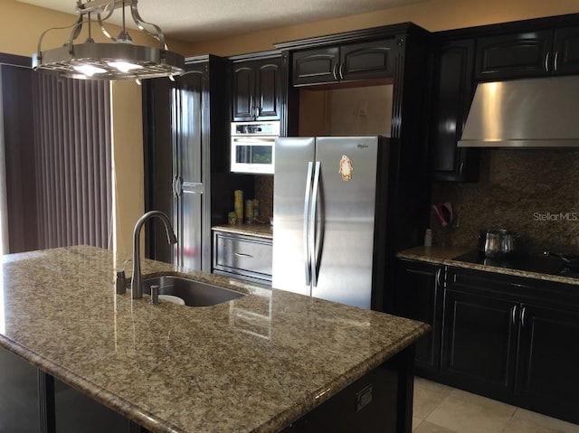 kitchen with sink, appliances with stainless steel finishes, light stone counters, extractor fan, and decorative backsplash