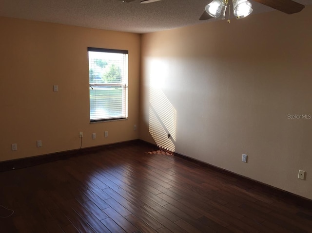 empty room featuring ceiling fan, a textured ceiling, and dark hardwood / wood-style flooring