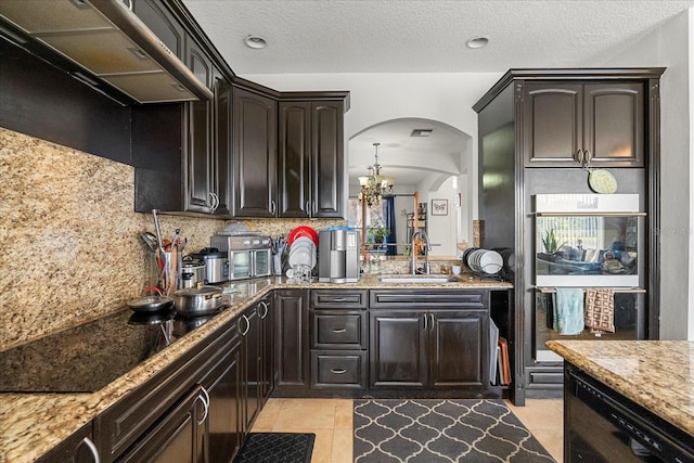 kitchen featuring decorative backsplash, black electric cooktop, dark brown cabinets, ventilation hood, and a sink