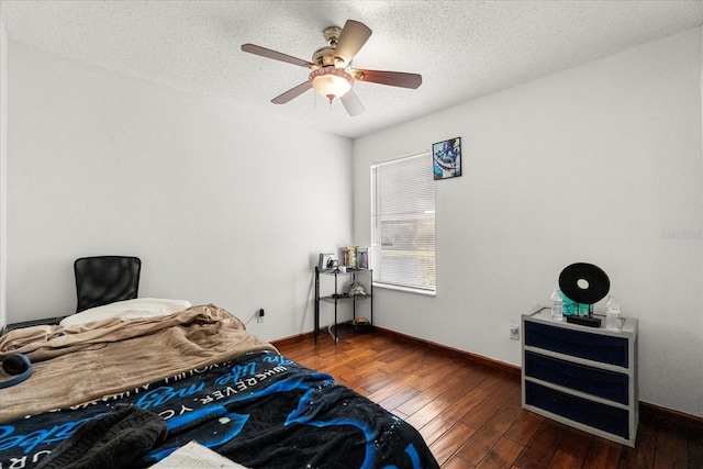 bedroom featuring dark wood-style flooring, ceiling fan, a textured ceiling, and baseboards