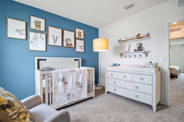 carpeted bedroom featuring a nursery area