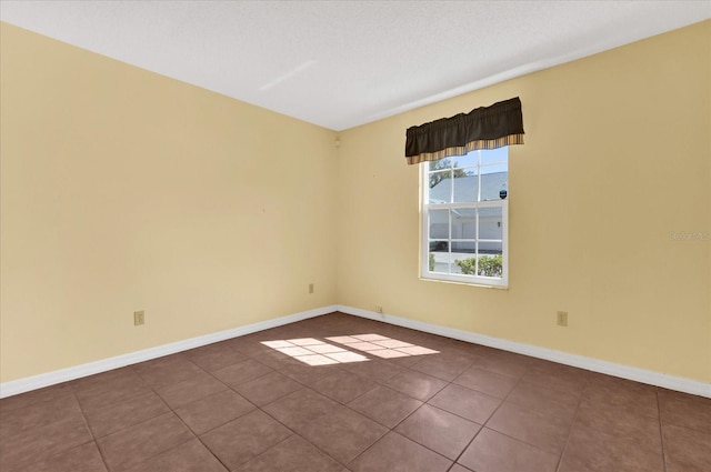 tiled empty room with a textured ceiling