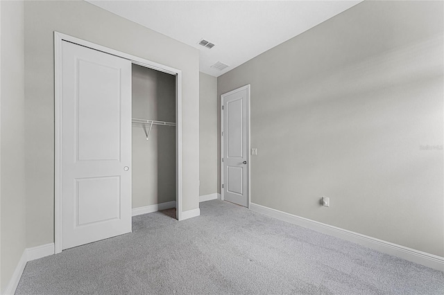 unfurnished bedroom featuring light colored carpet and a closet