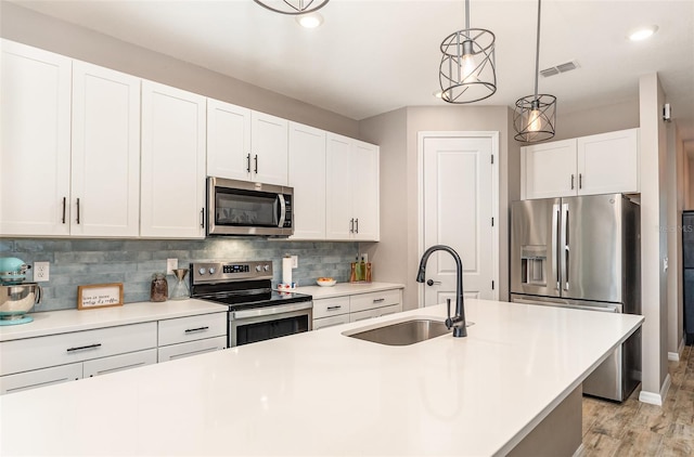 kitchen featuring light countertops, appliances with stainless steel finishes, a sink, and visible vents