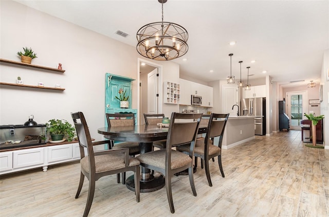 dining space with a notable chandelier, recessed lighting, visible vents, baseboards, and light wood-style floors