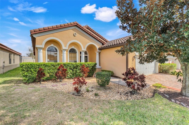 mediterranean / spanish-style home featuring a garage and a front yard