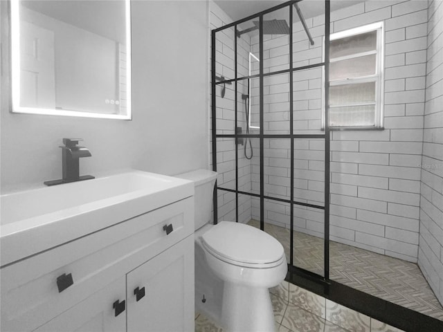 bathroom featuring vanity, tiled shower, and toilet