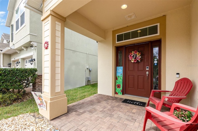 doorway to property featuring stucco siding