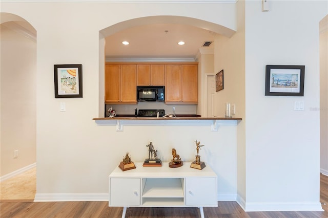 8168 Boat Hook Loop Unit 707, Windermere, FL 34786 - kitchen featuring black microwave, range, wood finished floors, recessed lighting, and arched walkways
