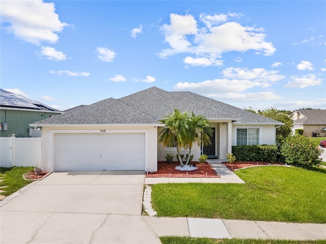 ranch-style home with a garage and a front lawn