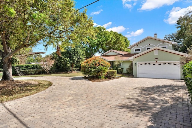 view of front of home with a garage, decorative driveway, and stucco siding