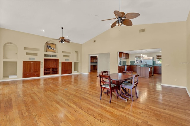 dining room featuring built in features, visible vents, light wood-style floors, and a ceiling fan