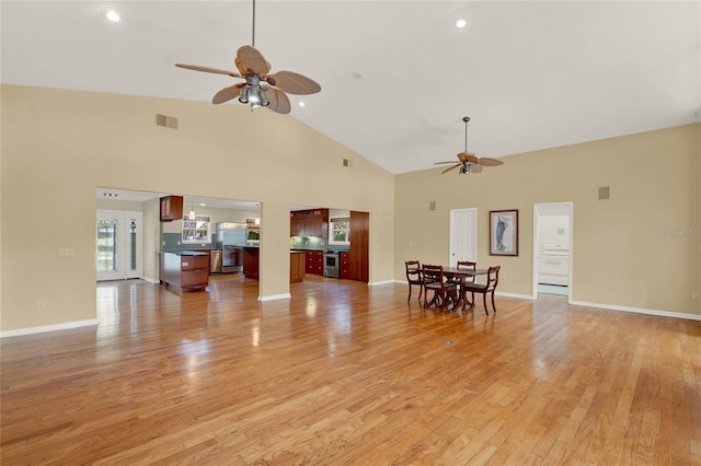 unfurnished living room with ceiling fan, light wood-style flooring, and baseboards